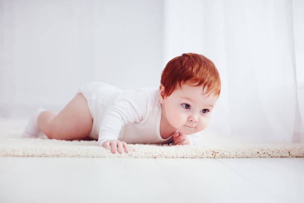 istock curious, nine months old baby crawling on carpet at home 922773878