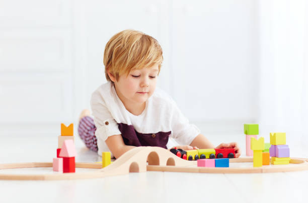 istock cute kid playing with toy railway at home 922774376