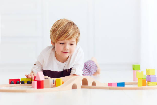 istock cute kid playing with toy railway at home 922774756