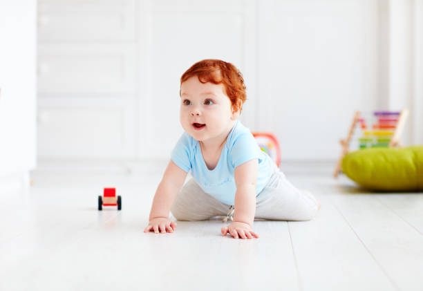 istock cute infant baby crawling on the floor at home 922776002