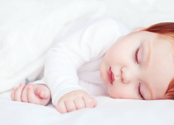 istock beautiful redhead infant baby sleeping in bed 922776662