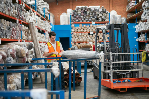istock Male worker with packed carpet in industry 922778330