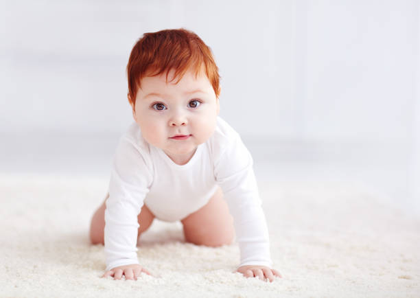 istock happy, nine months old baby crawling on carpet at home 922778440
