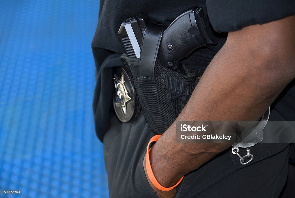 Bear Arms An armed patrolman stands on a platform in a North American transit station. Police Force Stock Photo