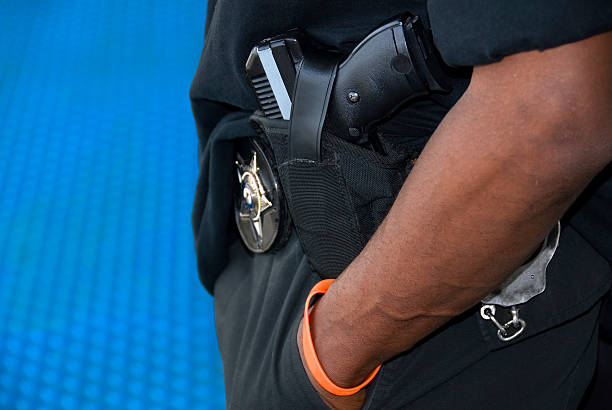 Bear Arms An armed patrolman stands on a platform in a North American transit station. sergeant badge stock pictures, royalty-free photos & images