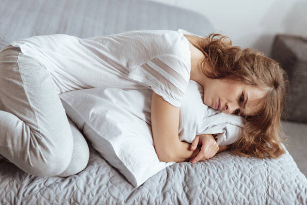 istock Sad woman lying in bed and embracing her pillow 922783450