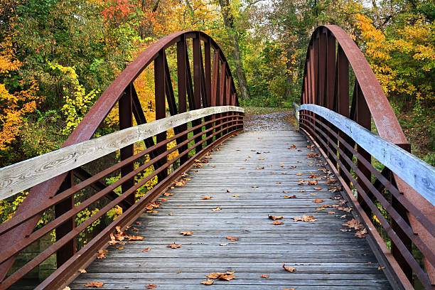 Traditional wooden bridge crossing a narrow point of the saltwater tidal pond of the Hamarikyu Gardens, Chuo ward, Tokyo, Japan
