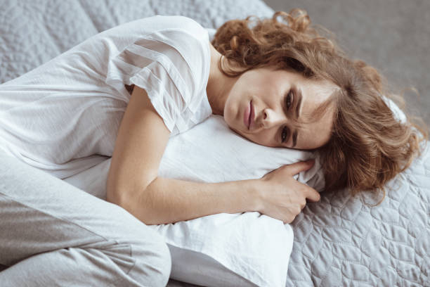 istock Nervous brunette lady embracing pillow and thinning about something depressing 922783578