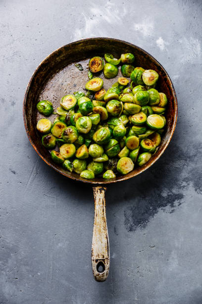 fried Brussels sprouts in frying pan fried Brussels sprouts in frying pan on concrete background brussels sprout stock pictures, royalty-free photos & images