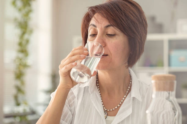 istock Middle aged woman drinking water 922785888