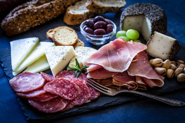 delizioso antipasto su tavolo color bluastro - salami antipasto sausage buffet foto e immagini stock