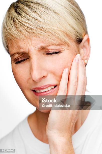 Woman Grabbing Her Cheek Symbolizing Tooth Pain Stock Photo - Download Image Now - Adult, Beautiful People, Beautiful Woman