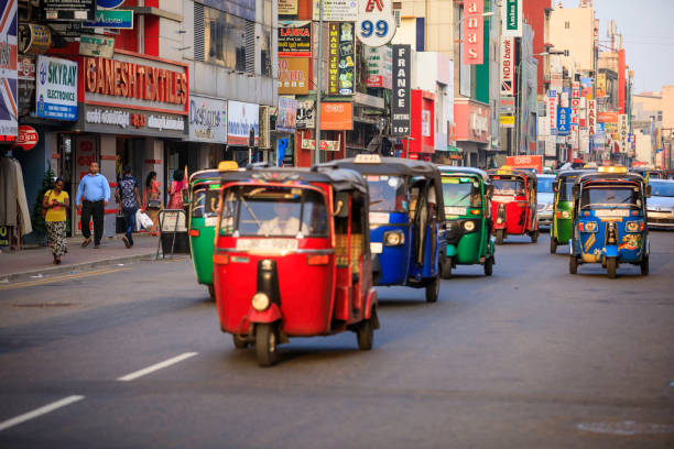 Tuktuk taxi on the streets of Colombo; Sri Lanka Colombo, Sri Lanka - December 7, 2016: Traffic and busy street in the center of Colombo, the capital city of Sri Lanka. Tuktuk taxi, the motorized development of the traditional pulled rickshaw, ride on a city street. taxi sri lanka stock pictures, royalty-free photos & images