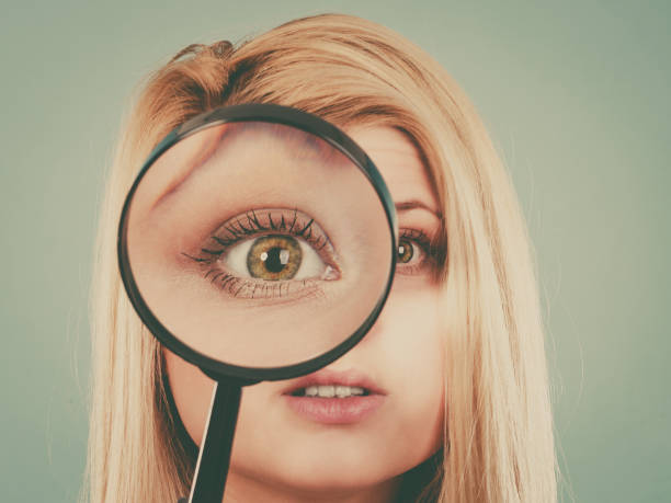 istock Woman looking through magnifying glass 922789428