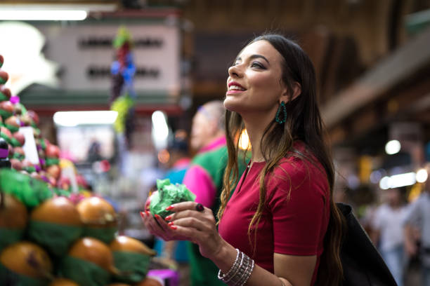 giovane donna che fa shopping sul mercato locale - tropical culture foto e immagini stock