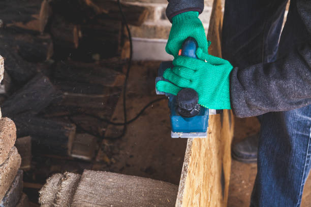 istock hands in gloves plan the wood plate with an electric plane 922793856