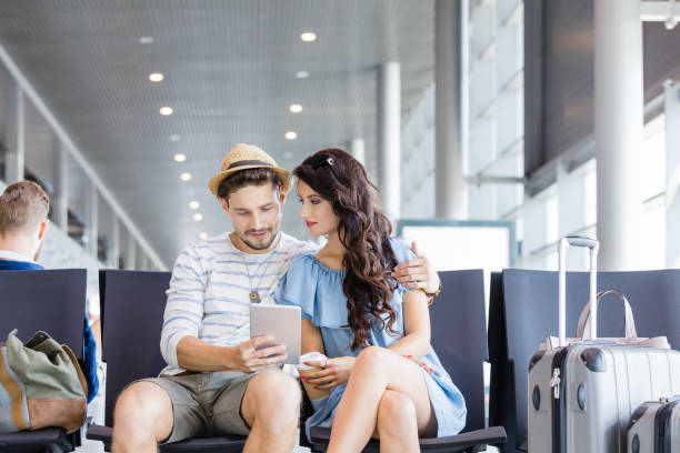 istock Young couple waiting for flight in airport lounge 922794148