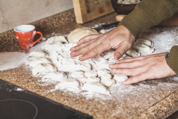 istock Hands of man over dough pieces on marble countertop 922796662