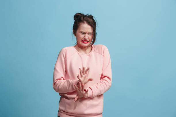 istock Young woman with disgusted expression repulsing something, isolated on the blue 922797456