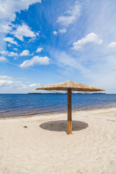 Sunshade on sandy beach on summer day Artificial canopy from the sun in the form of a large mushroom stands on a deserted sandy beach by the sea on a hot day civilized stock pictures, royalty-free photos & images