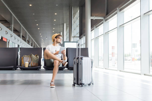 istock Young handsome man waiting for flight in airport lounge 922797826
