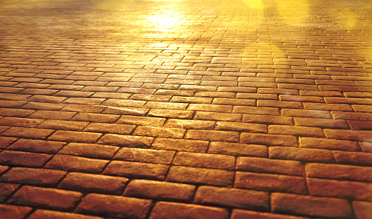 Road background of stone slabs with sun reflection and golden glitters. Religious and meditation concept.