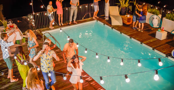 istock People dancing and having good time at night party by pool 922799516