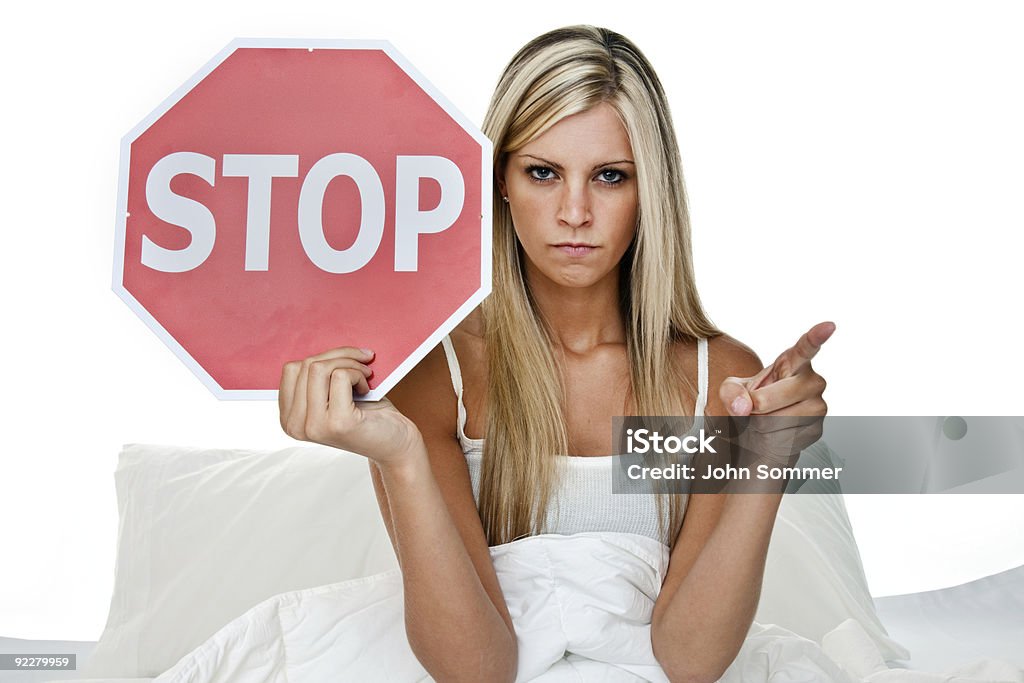 Mulher na cama, segurando uma placa de pare - Foto de stock de Mulheres royalty-free