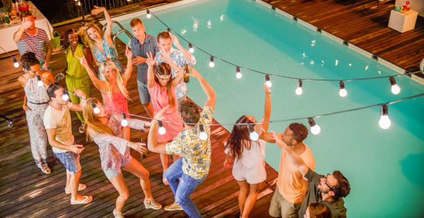People dancing and having good time at night party by pool