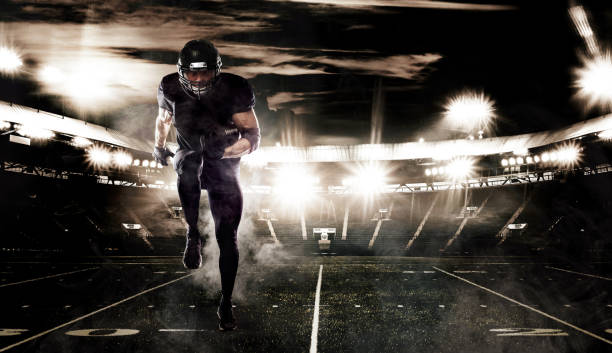 American football sportsman player on stadium in action. Sports banner and wallpaper with copyspace. stock photo
