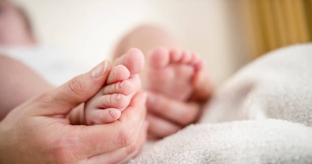 istock Mother's hands caressing her baby's feet 922802710