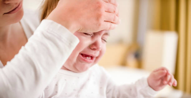 istock Mother checking baby's temperature with her hand 922802724