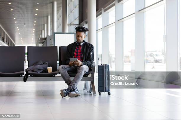Young African Using Digital Tablet In Airport Lounge Stock Photo - Download Image Now