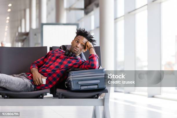 Young Man Waiting For Flight In Airport Lounge Stock Photo - Download Image Now - Adult, Adults Only, African Ethnicity
