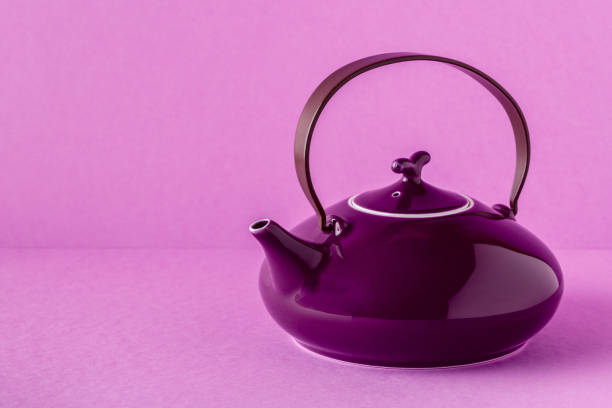 istock Purple teapot and cups on a lilac background 922809316