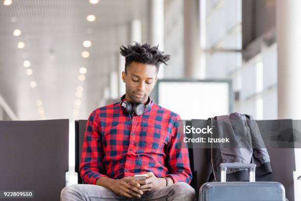 Young African Using Mobile Phone In Airport Lounge Stock Photo - Download Image Now - Adult, Adults Only, African Ethnicity