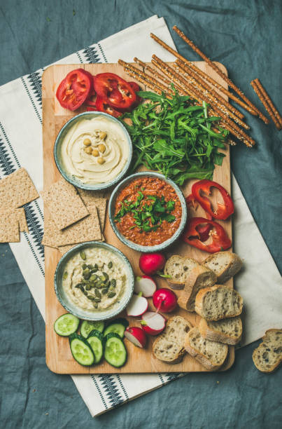 istock Vegetarian dips hummus, babaganush, muhammara on wooden board 922810456