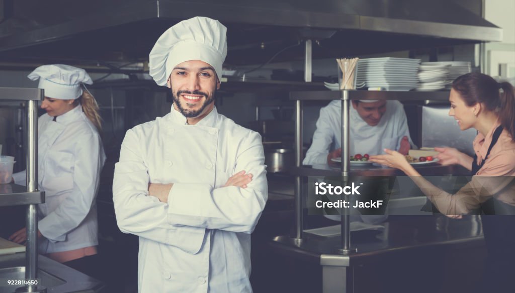 Retrato del chef sonriendo satisfecho en cocina de restaurante - Foto de stock de Chef libre de derechos