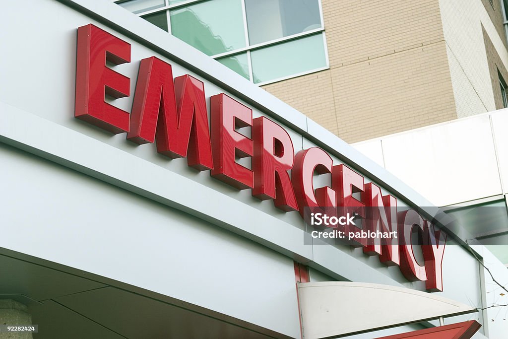 Close up photo of red large letters spelling emergency Large red EMERGENCY sign on hospital entrance. Raw original. Emergency Sign Stock Photo