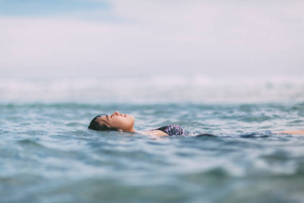 femme flottant dans la mer - floating on water women swimming water photos et images de collection