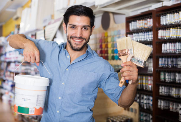 istock Happy man choosing brushes and varnishes 922827190