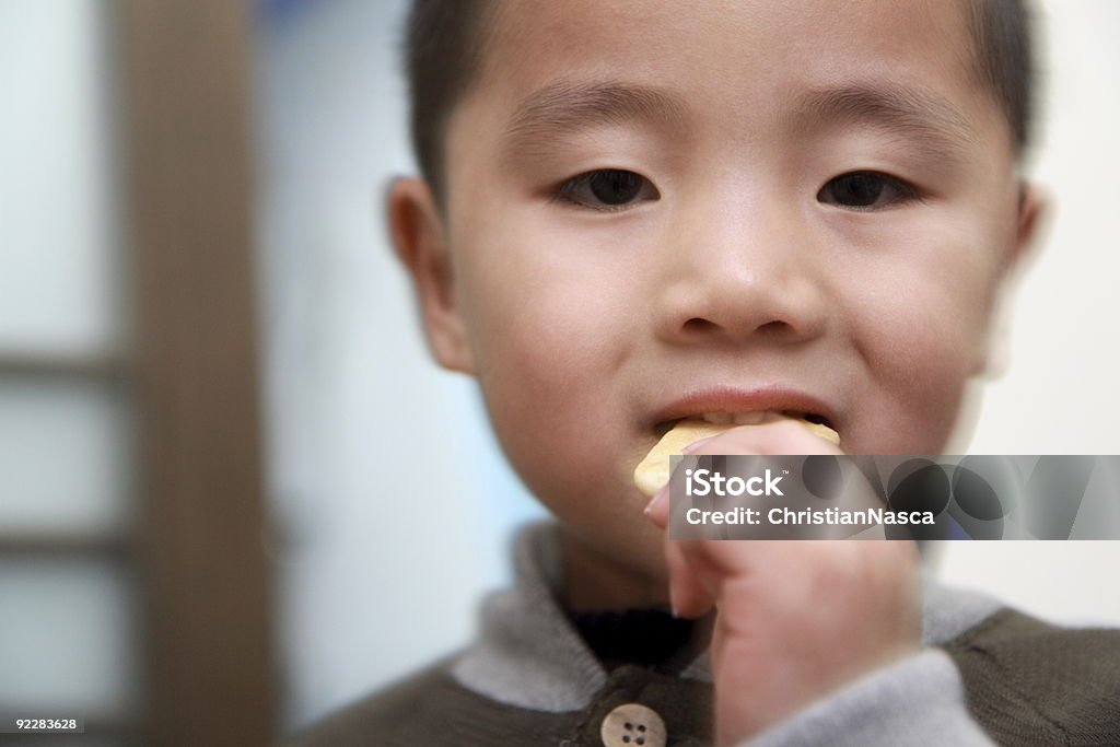 Китайский мальчик ест печенье - Стоковые фото Есть роялти-фри