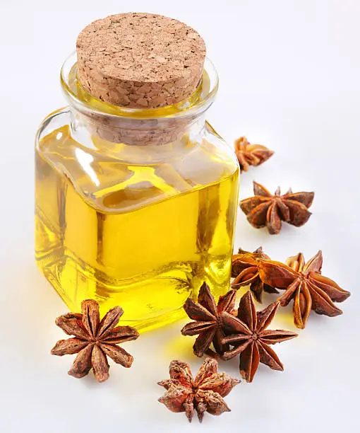 Photo of Aniseed oil with nuts on a white background