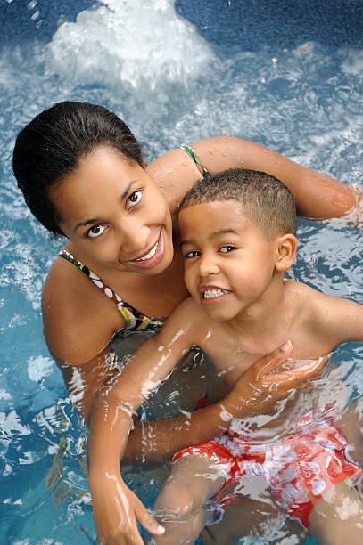 Mother and son swimming in pool stock photo