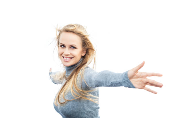 Blonde woman with radiant blue earrings, and a beaming smile, set against a vivid gradient blue background. The composition highlights her elegance and charm look