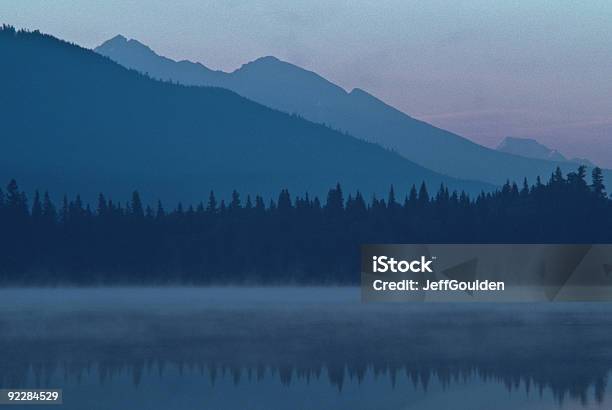 Foggy Mountains And Reflections In A Lake Stock Photo - Download Image Now - Bowron Lake Provincial Park, Atmospheric Mood, Beauty In Nature