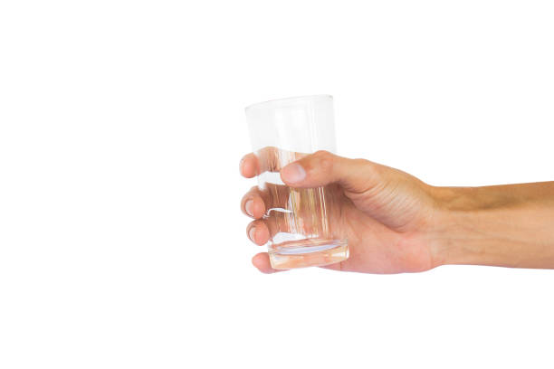 istock Close-Up Of Hand Holding Empty Glass Against White Background 922846972