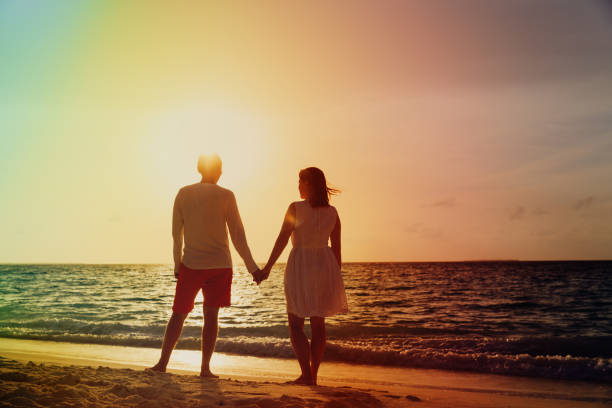 istock Romantic couple on tropical beach at sunset 922849332
