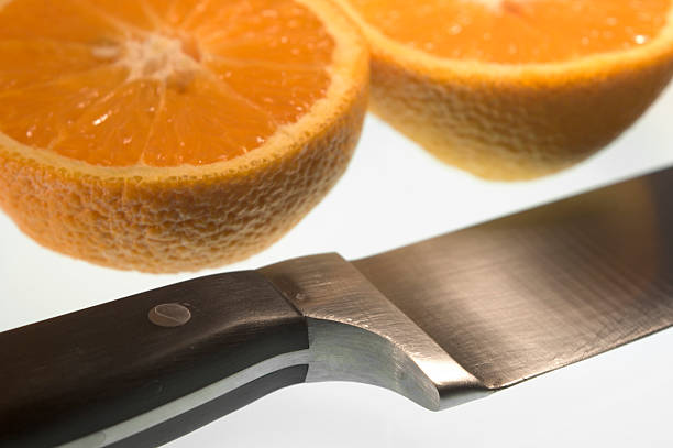 closeup of sliced orange and knife stock photo