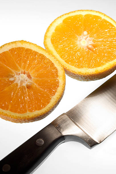 sliced orange with knife stock photo